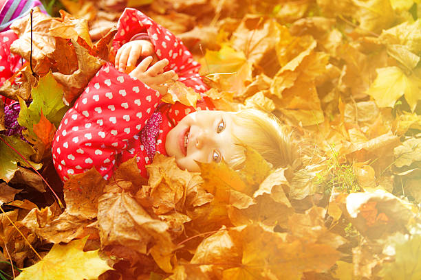 istock cute little girl playing with autumn fall 492383590