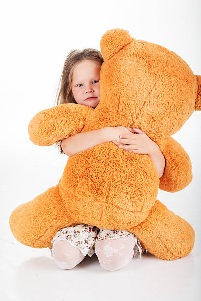 istock Child girl is holding teddy bear, studio 492390772
