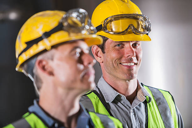 istock Two men wearing hardhats, vests and safety glasses 492392168