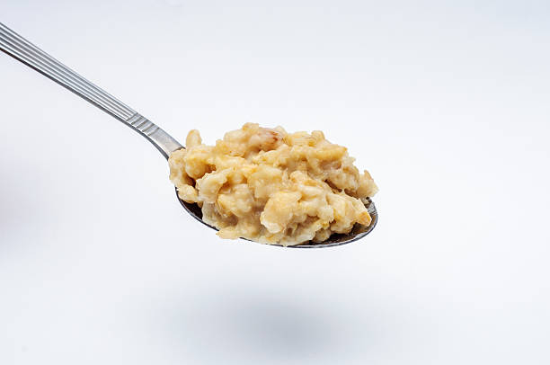 istock Spoon with porridge on white background 492393348