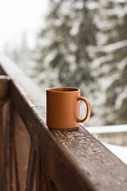 istock Cup with hot drink over winter forest background 492394476