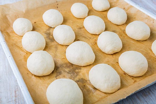 istock Hand made bread dough cut and formed into bread rolls 492395760