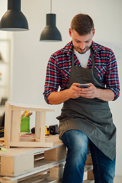 istock Designer Using Smart Phone In His Furniture Workshop. 492396428