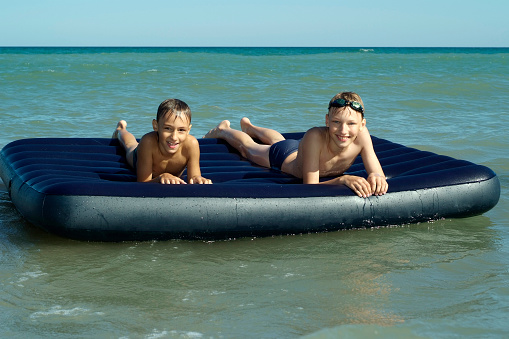 two little boys floating on air mattress