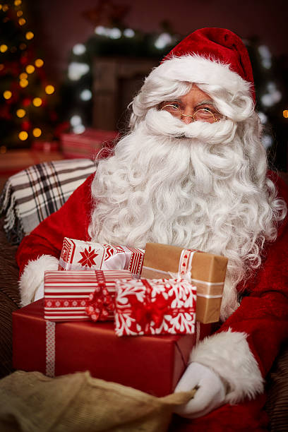 istock Santa Claus with stack of christmas presents 492397950