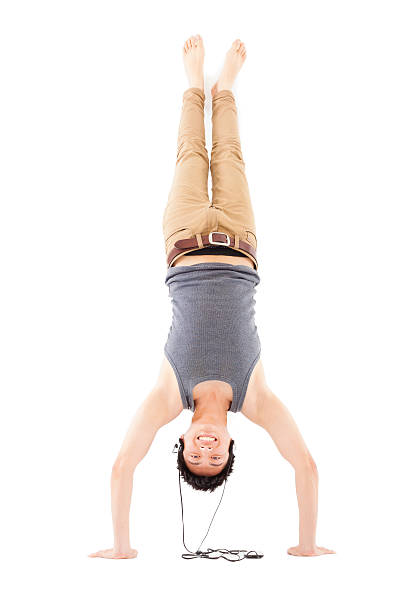 istock young man doing a handstand against and listening music 492400017