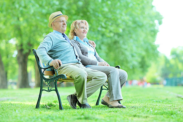 istock Elderly couple relaxing on a bench in park 492400343