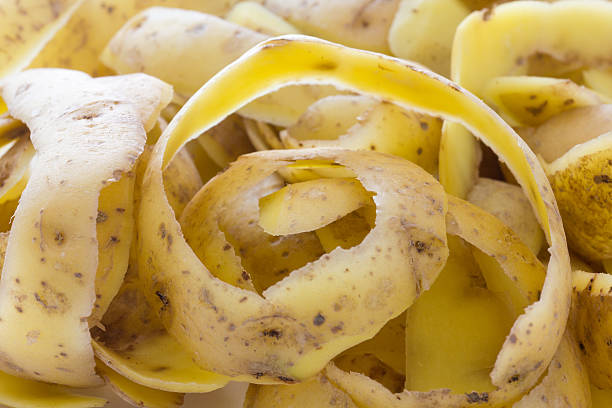 новый картофель кожи или peels фоне - potato skin стоковые фото и изображения