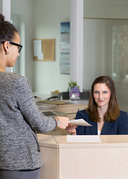 istock Clerk is handing over a document to customer 492401841