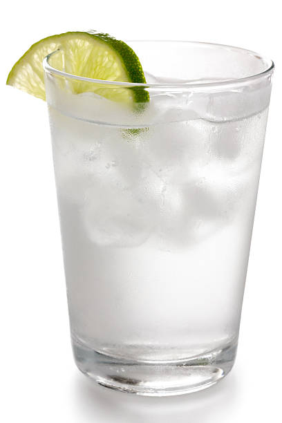 istock Simple glass of water with floating ice cubes and lime 492403191