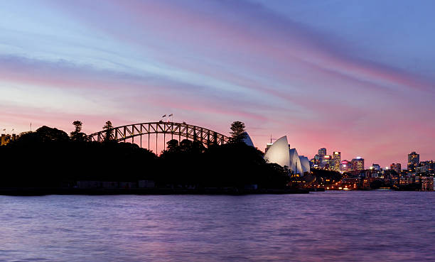 rosa e rosso cielo al tramonto a sydney, australia - sydney opera house sydney australia opera house bridge foto e immagini stock