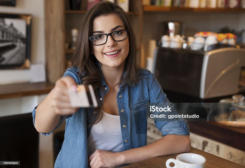 Smiling woman paying for coffee by credit card Smiling woman paying for coffee by credit card  Adult Stock Photo