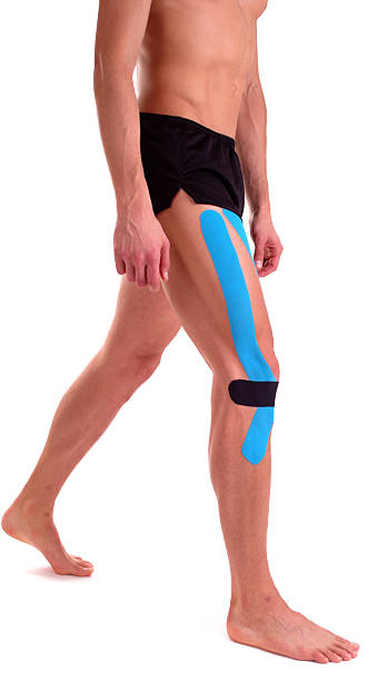 bande de kinésiologie sur les genoux. physiothérapie pour sportif - human knee physical injury bandage muscular build photos et images de collection