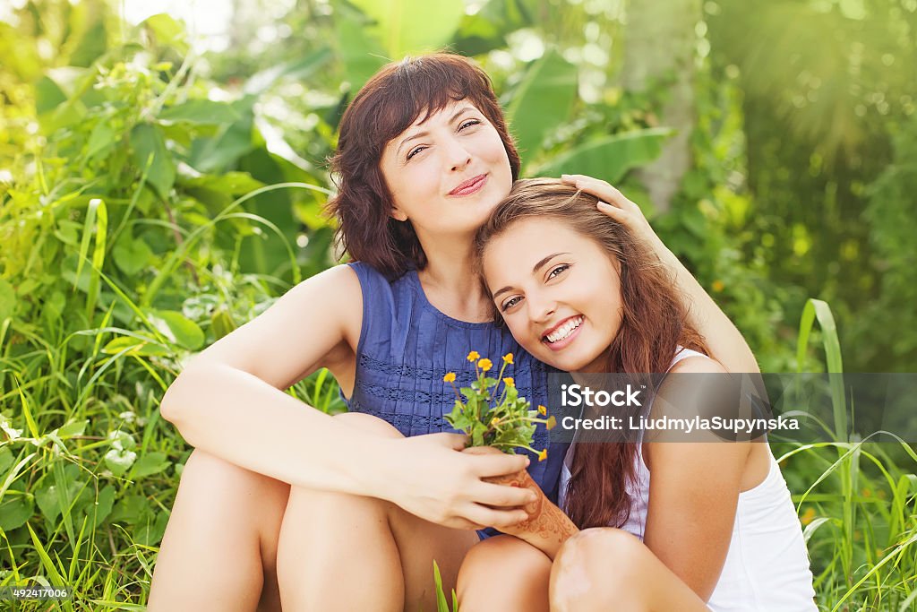 mother and her grown up daughter caucasian mother and daughter sitting and hugging each other in a summer field (looking at camera) Aunt Stock Photo