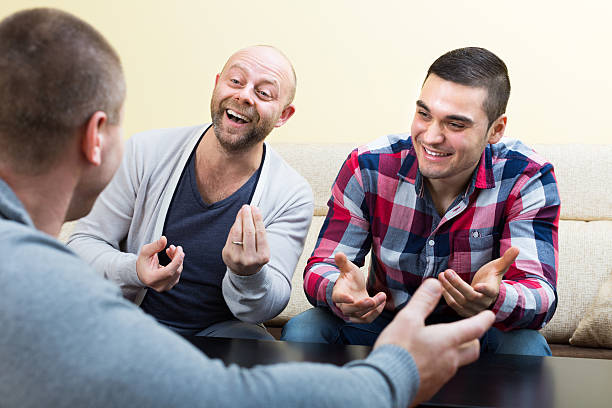 istock Three male friends talking at home 492419830