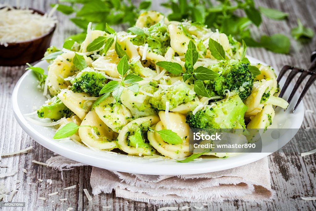 homemade pasta orecchiette with broccoli, Parmesan cheese and basil homemade pasta orecchiette with broccoli, Parmesan cheese and basil on a wooden table 2015 Stock Photo