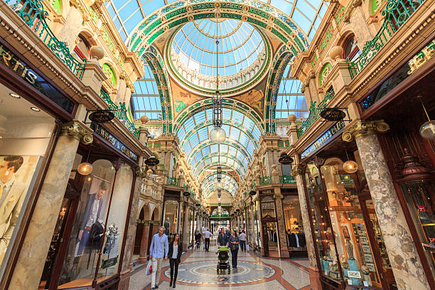 Shoppers walking through County Arcade in Leeds, West Yorkshire Leeds, UK - October 02, 2015: Shoppers walking through County Arcade in Leeds, West Yorkshire. This arcade is part of the Victoria Quarter in Leeds. The Victoria Quarter was redeveloped in the late 1980s and is largely populated by upmarket retailers and cafes.   leeds photos stock pictures, royalty-free photos & images