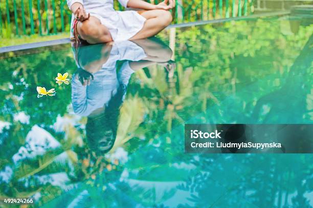 Woman Meditating At Pool Side Stock Photo - Download Image Now - 2015, Abstract, Adult