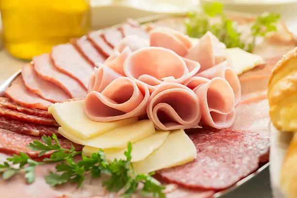 Cold cuts. Meat and cheese snacks on a buffet table, close up.