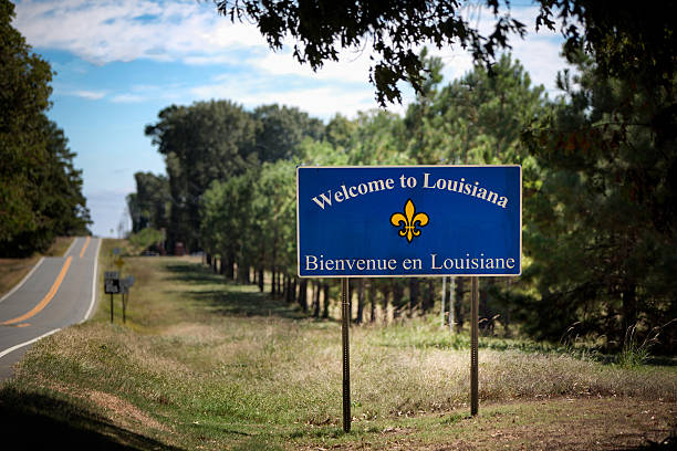 State Line Sign Saying Welcome to Louisiana Remote location state line from Texas to Louisiana on a two lane highway with a sign welcoming travelers into the state of Louisiana. The sign also has the French version, Bienvenue in Louisiane. baton rouge stock pictures, royalty-free photos & images