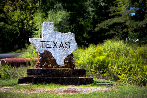 Rock sign signifying entry into the State of Texas.  Sign is in the shape of the state itself.