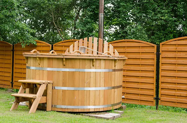 Photo of modern wooden water hot tub with stairs outdoor