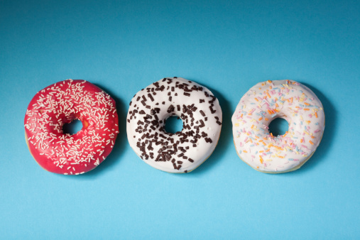 top view of three donuts isolated on blue background with copyspace
