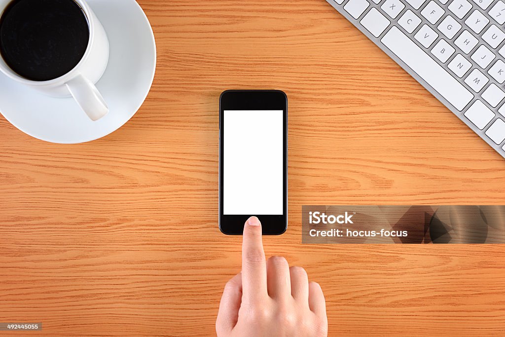 Hand touching blank screen smart phone on business desk Hand touching blank white screen smart phone on business desk. Adult Stock Photo