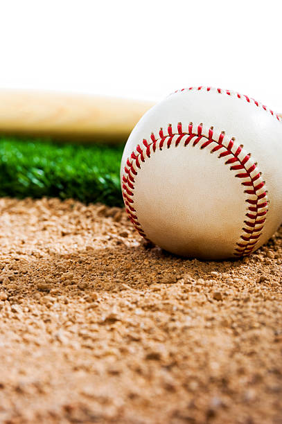 istock New Baseball and Bat sitting on infield dirt 492446939