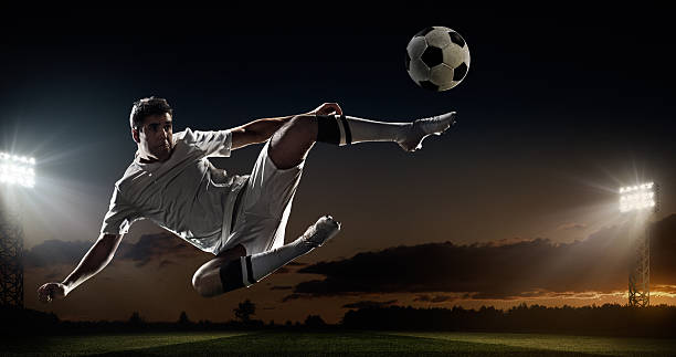 istock Soccer player kicking ball in stadium 492450112