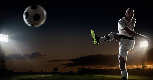 istock Soccer player kicking ball in stadium 492450370