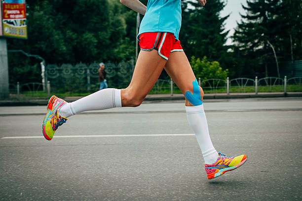 joven atleta de correr una maratón - kinesio fotografías e imágenes de stock