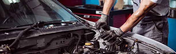 Close-up of car mechanic fixing automotive engine