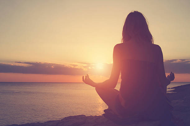 istock Young woman practicing yoga on the beach. 492453916