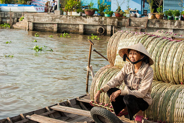 Portrait of a vendor of bamboo baskets Soc Trang, Vietnam - JAN 19, 2014: Portrait of a vendor of bamboo baskets at Nga Nam floating market in Soc Trang on Jan 19, 2014. Nga Nam are the largest and most beautiful local market on the river located in Soc Trang, Vietnam vietnamese girls for sale stock pictures, royalty-free photos & images