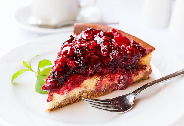 istock Wild berries cake with green mint on plate with fork 492458342