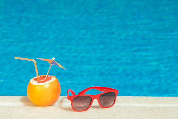 istock Red sunglasses and Grapefruit with drinking straw and paper parasol 492459358