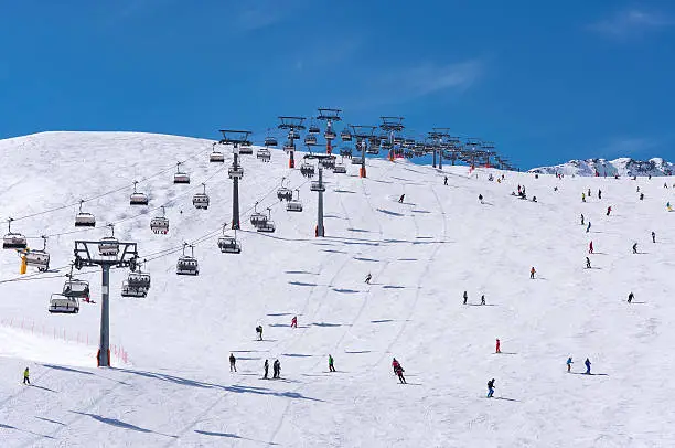 Skiers and double chairlift in Alpine ski resort in Solden in Otztal Alps, Tirol, Austria