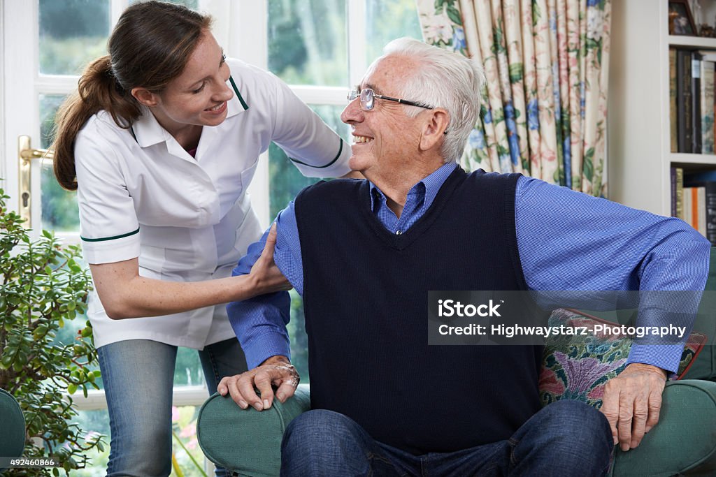 Care Worker Helping Senior Man To Get Up Care Worker Helping Senior Man To Get Up Out Of Chair Senior Adult Stock Photo