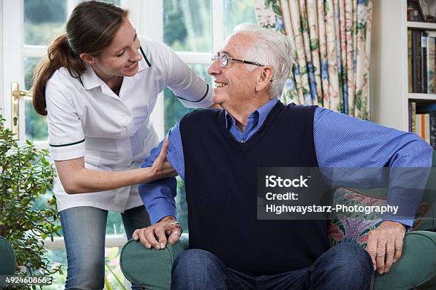 Care Worker Helping Senior Man To Get Up Stock Photo - Download Image Now - Senior Adult, Waking up, Chair