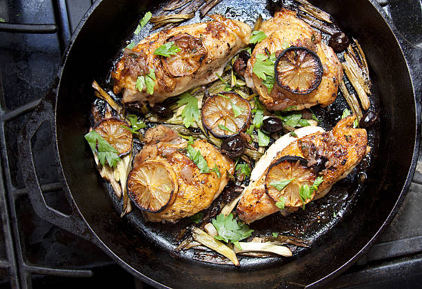 Roasted chicken with lemon slices on the stovetop Chicken breasts and thighs roasted with lemon slices, green onions and olives.   paleo diet stock pictures, royalty-free photos & images