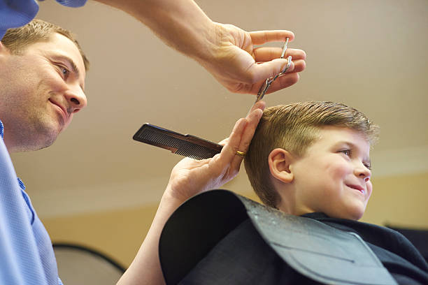 istock Young boy and barber in barber's shop 492462572