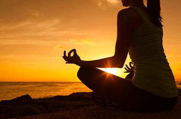 istock Woman meditating on the beach 492484686
