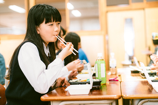 Japanese Teenage Students having lunch in classroom.