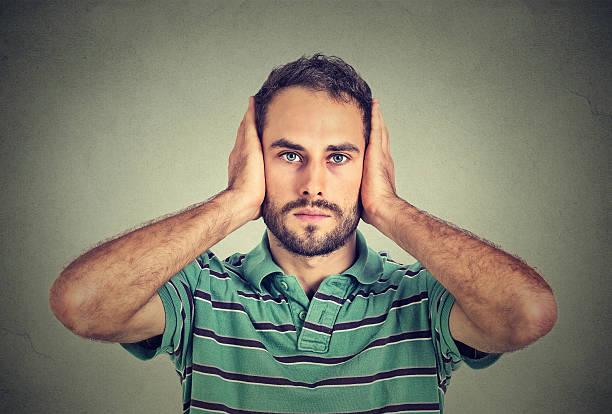 istock young man covering his ears with hands 492488500