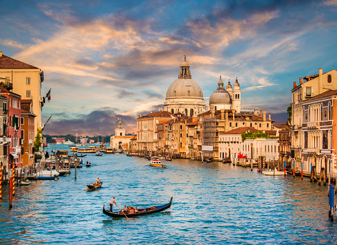 Beautiful view of famous Canal Grande with Basilica di Santa Maria Della Salute in golden evening light at sunset, Venice, Italy.