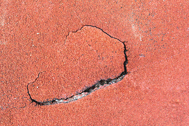 istock Cracked Red wet running track in stadium for design 492492270