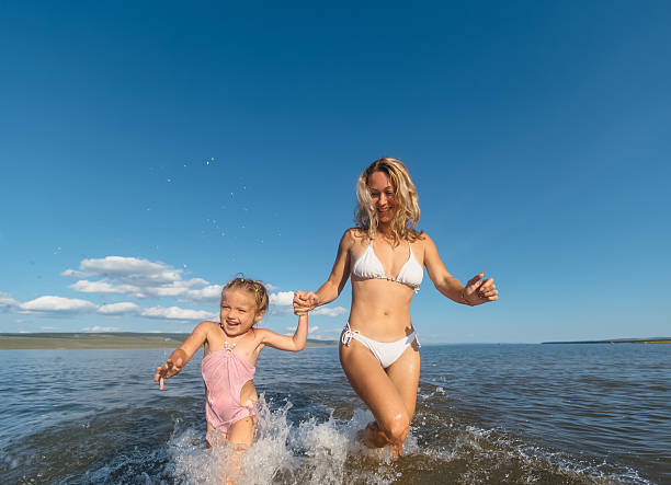 istock mother and daughter run on water 492493788