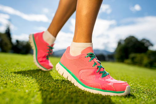 Woman running outdoors - close up on sports shoe