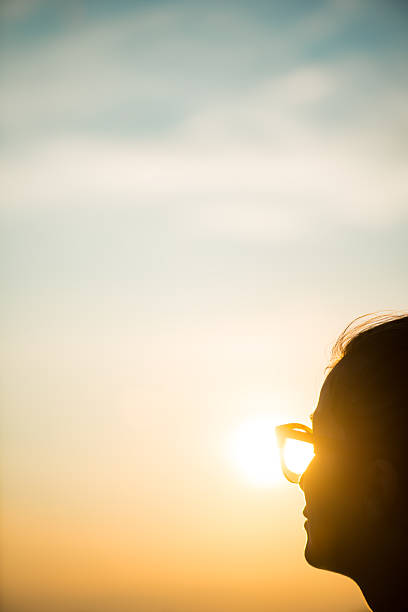 istock Young woman wearing sunglasses looking at sunset 492495378